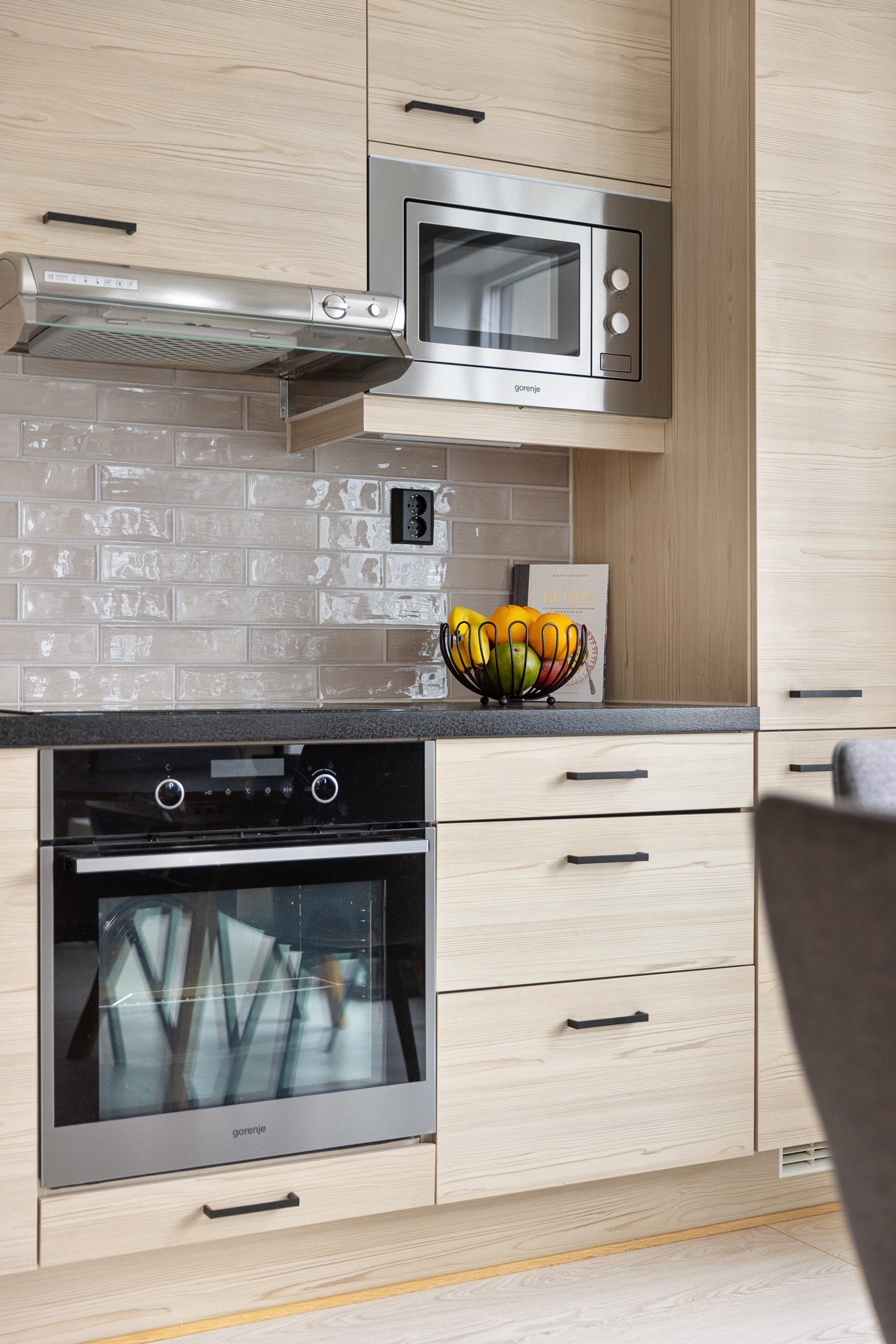 Delikate fliser over kjøkkenbenken og ventilator koblet på felles system. Galleribilde