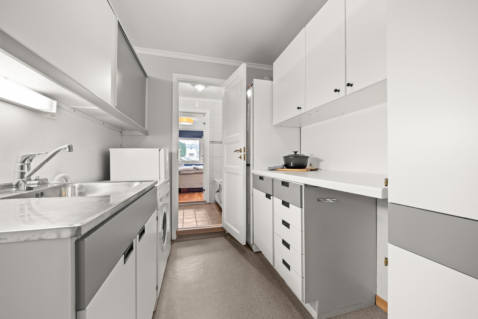 Fra badet kommer du rett til grovkjøkken, hvor det er opplegg for vaskemaskin Galleribilde