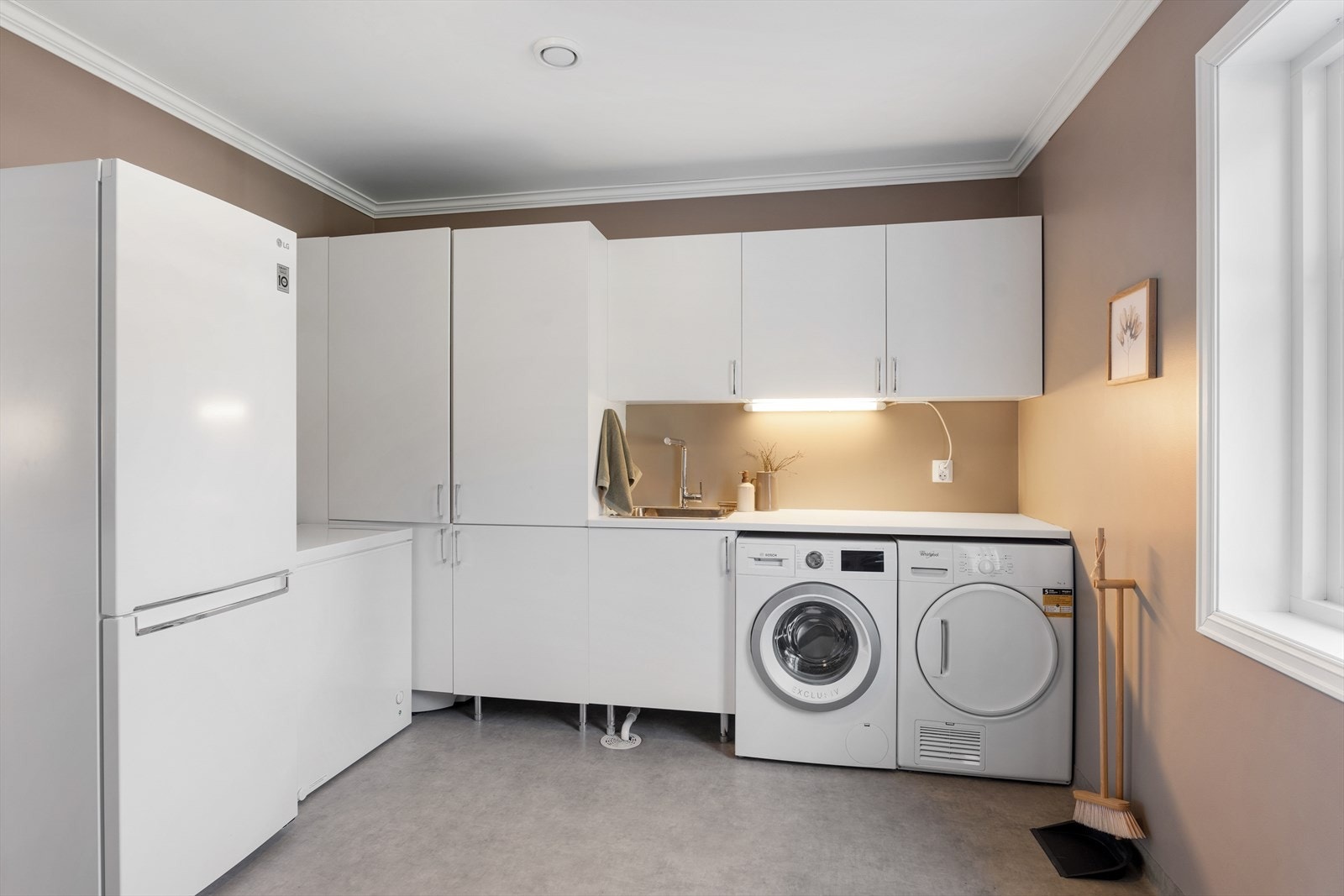 Stort og praktisk vaskerom med masse oppbevaringsplass i skap Galleribilde