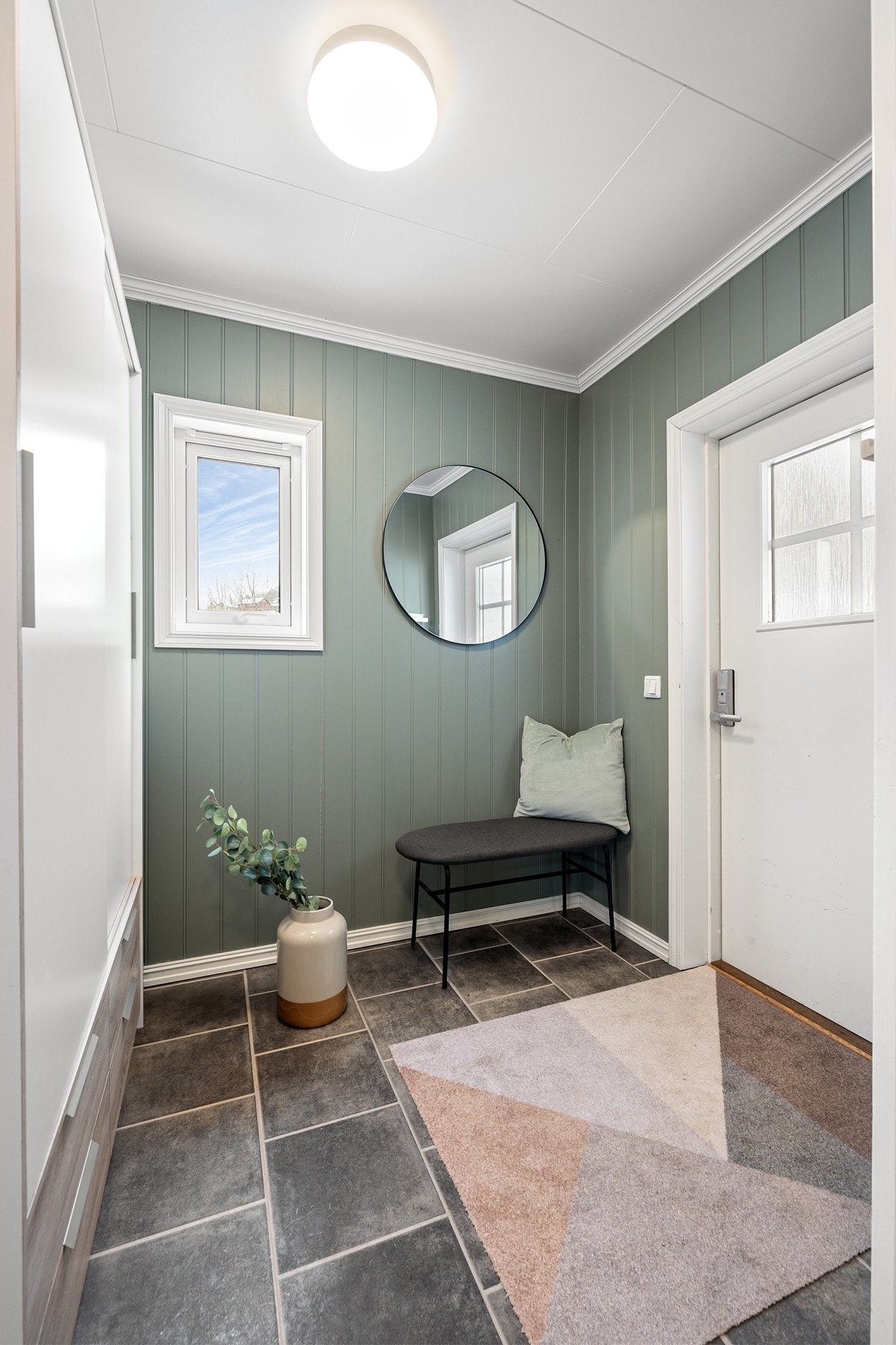 Entréen er flislagt og har innbydende overflater Galleribilde