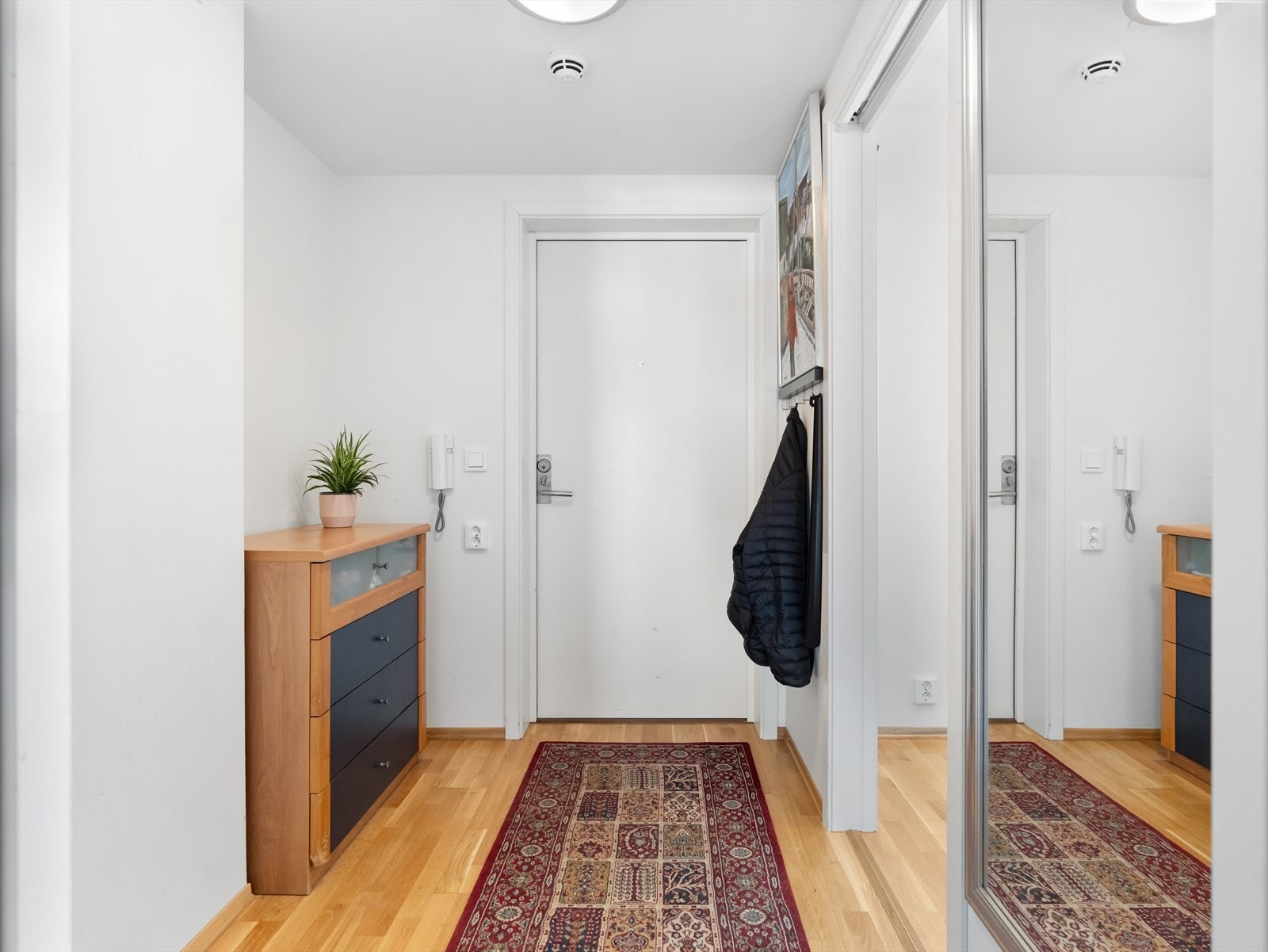 Fra garasjeplassen i kjelleren tar du enkelt heisen opp til 4. etasje. Leiligheten har en lys og innbydende entré med mulighet for garderobe. Galleribilde