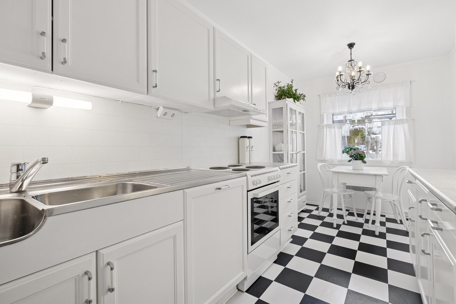 Benkeplaten er laminert, utstyrt med vaskekum, avrenningsplate og kjøkkenkran. Galleribilde