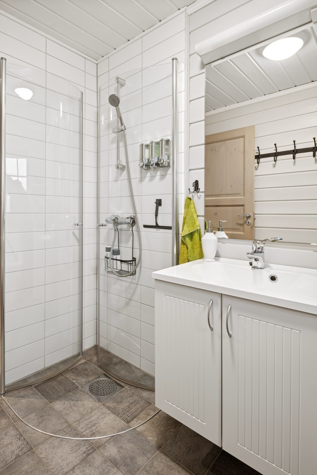 Badet har servantinnredning, gulvstående toalett og dusjhjørne Galleribilde