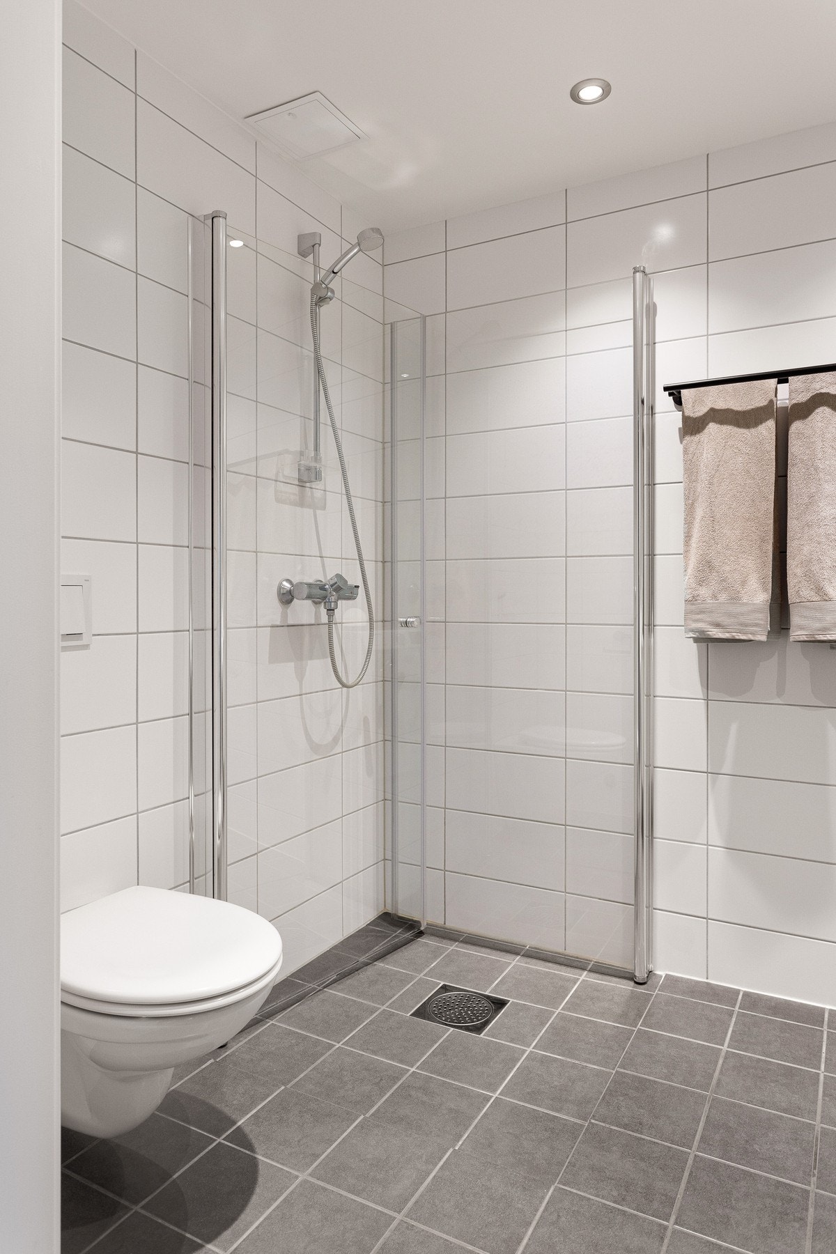 Badet er utstyrt med nedfelt servant, veggmontert toalett og dusjvegger/hjørne. Galleribilde