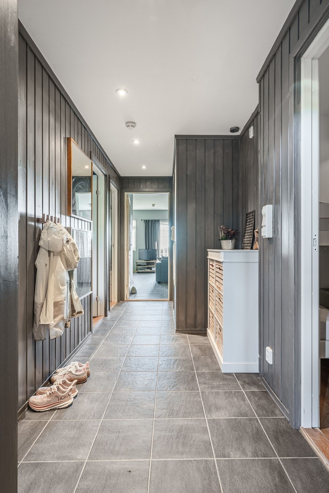 Du ønskes velkommen inn i en praktisk entré med plass til sko og oppheng av yttertøy. Entréen har god standard med flislagt gulv med gulvvarme, malt panel på veggene og downlights i himlingen. Galleribilde