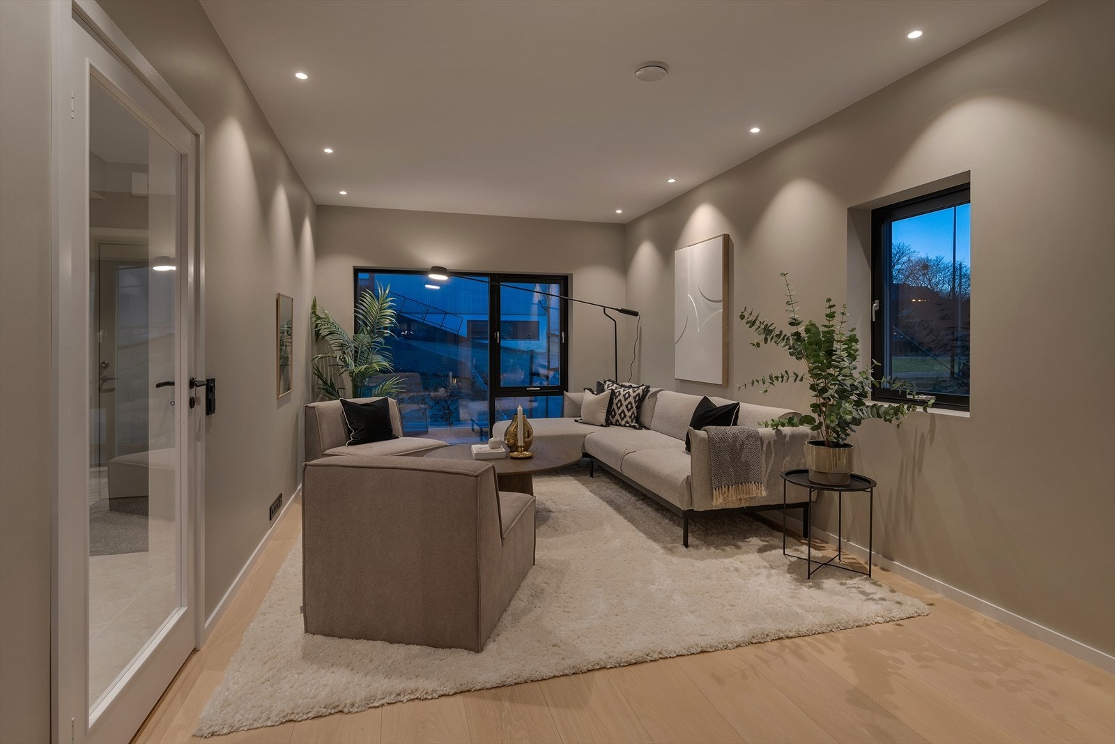 Moderne og stilfull stue med store vinduer som slipper inn rikelig med naturlig lys. Komfortabel og innbydende atmosfære. Galleribilde