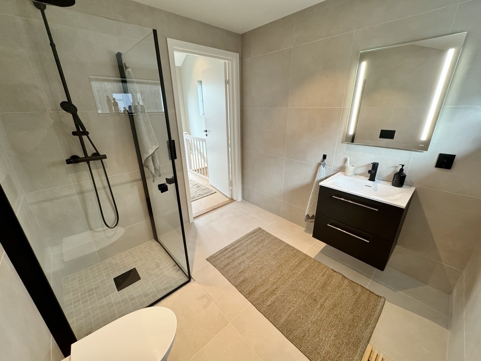 Baderom i toppetasjen. Dusj med innfellbare dører, vegghengt wc, speil med integrert belysning. Galleribilde