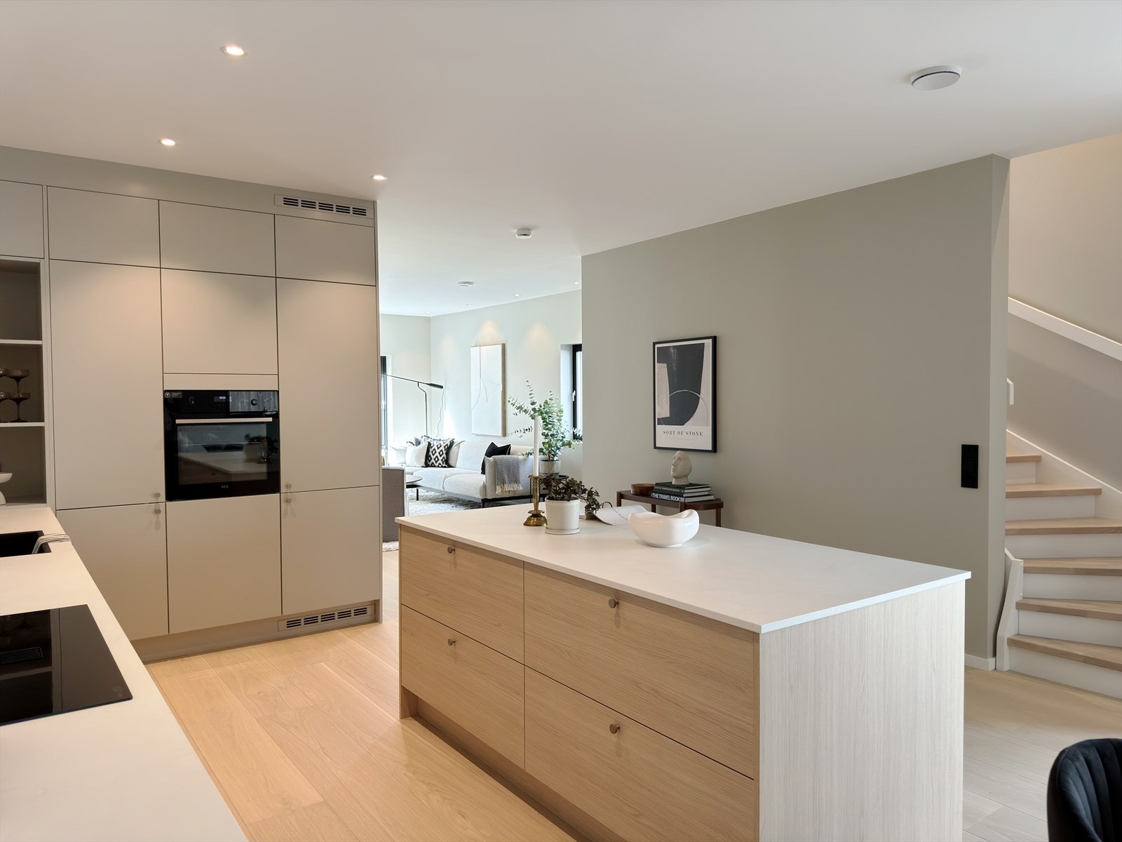 Moderne kjøkken med åpen løsning til stue, lys og romslig atmosfære, perfekt for sosialt samvær og daglig bruk. Galleribilde