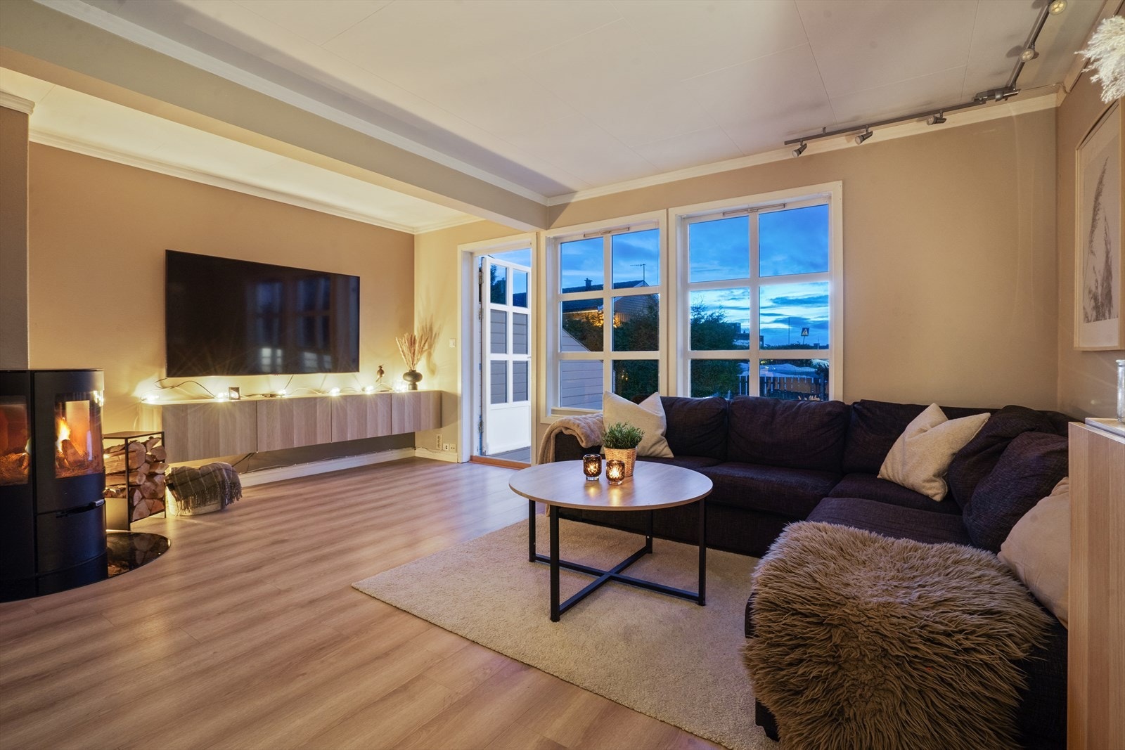 Atmosfæren i stuen er lun og god, med både peisovn og varmepumpe montert. Galleribilde