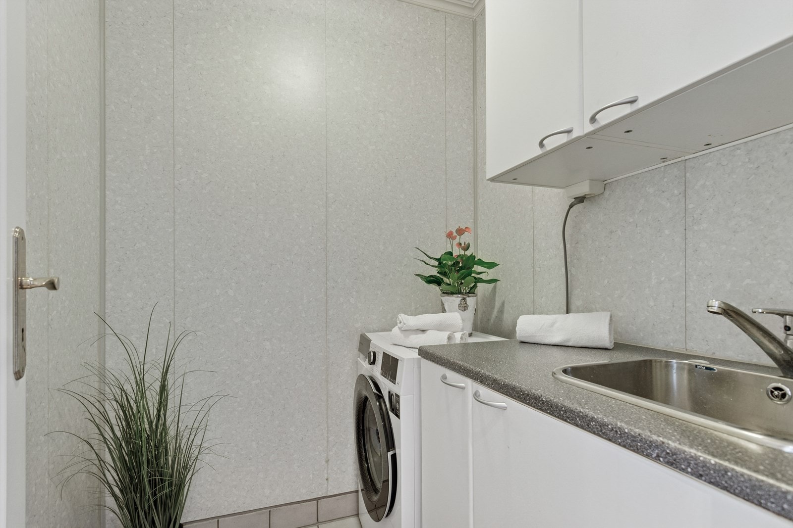 Vaskerom med vask og opplegg for vaskemaskin. Skapplass. Galleribilde