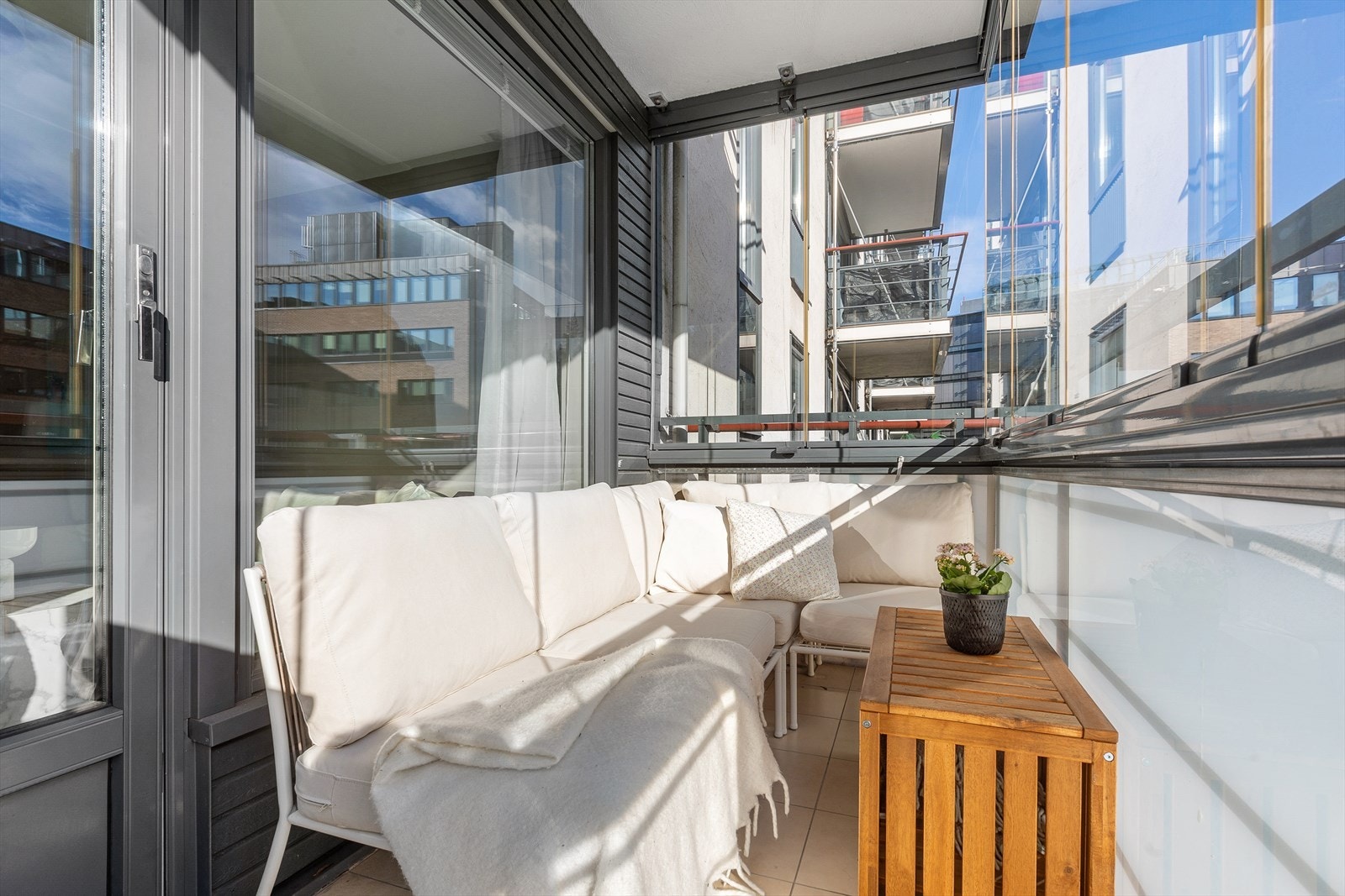 Østvendt innglasset balkong i betongkonstruksjon, med adkomst fra stue/kjøkken. Galleribilde