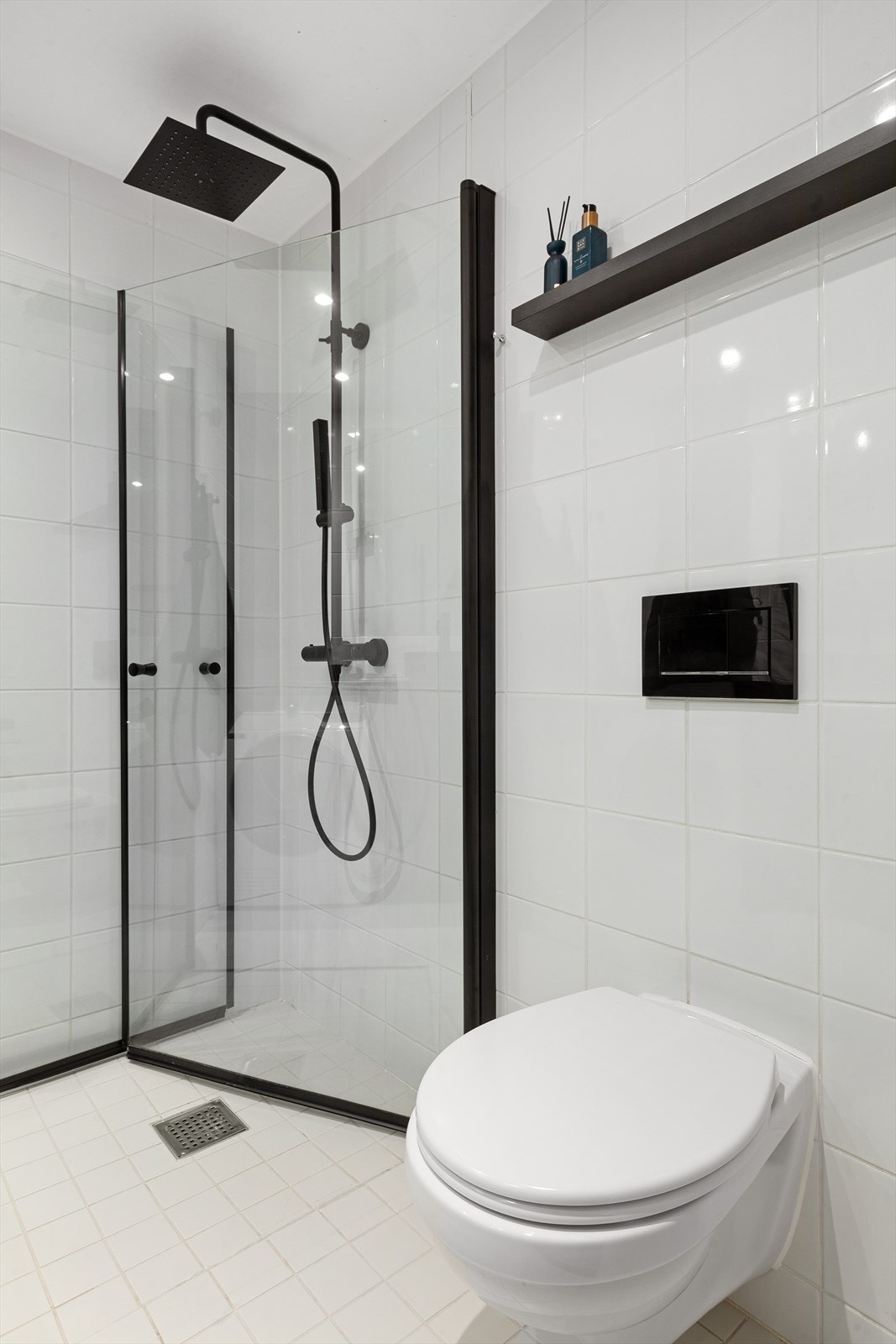 Flislagt gulv og vegger, nedsenket dusjsone med herdet glassdører. Vegghengt toalett, servant og opplegg for vaskemaskin. Galleribilde