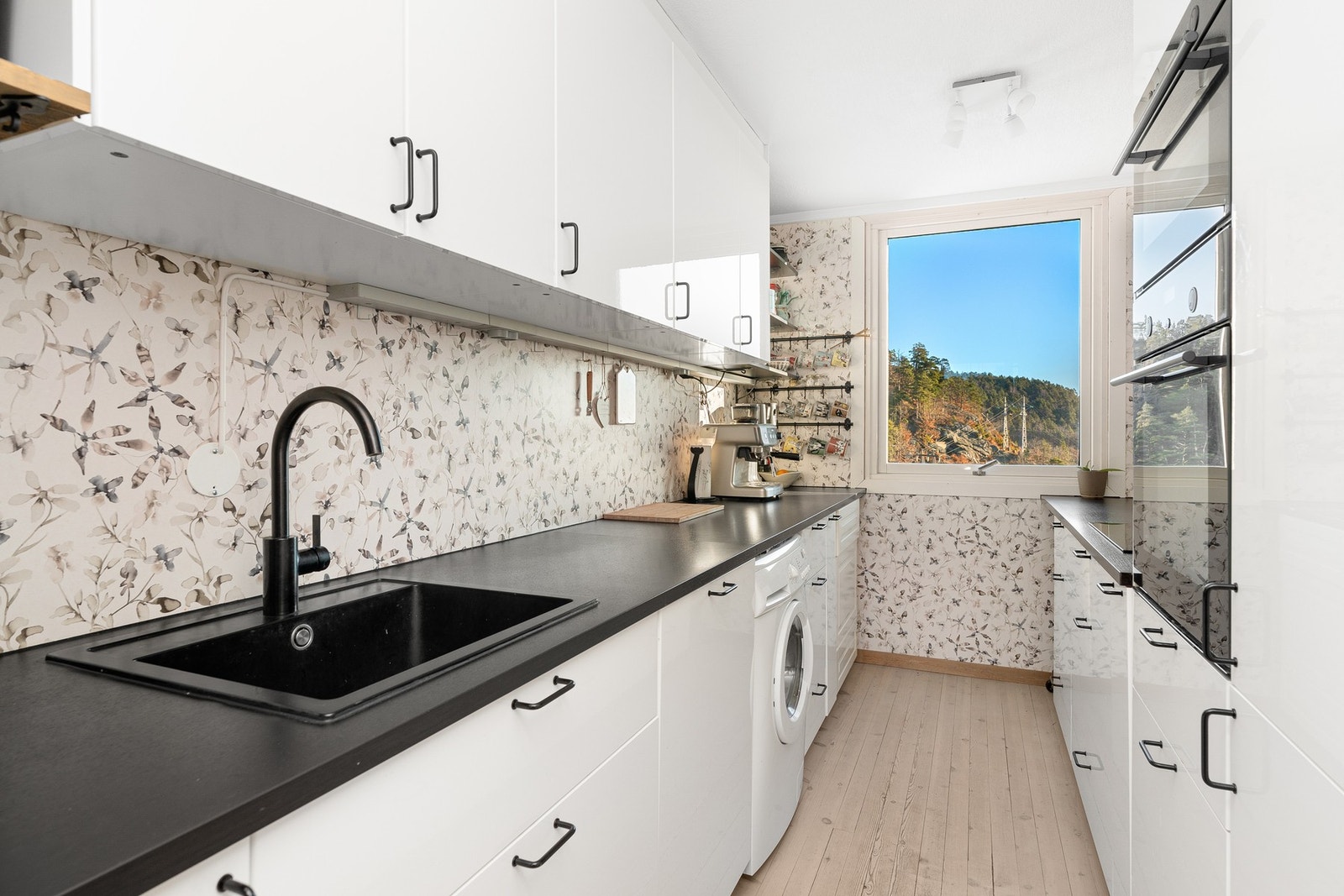 Kjøkkenet er delikat innredet med en tidløs hvit innredning. Galleribilde