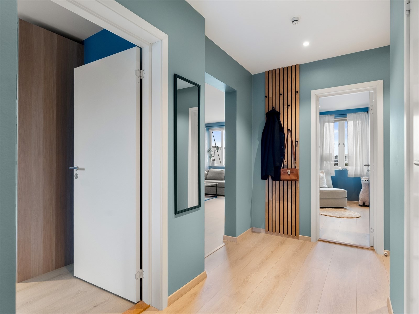 Leiligheten har en svært innbydende og romslig entré, med plass til å henge fra seg yttertøy på knaggrekke dekorert på spilevegg. Galleribilde