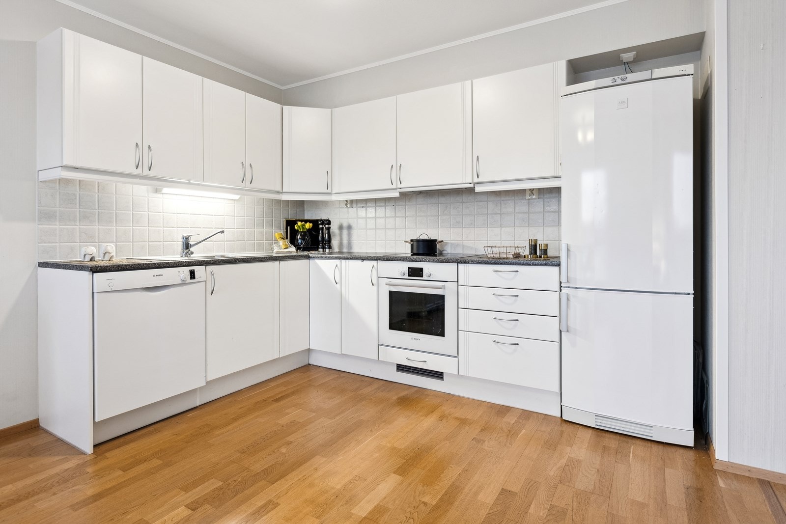 Kjøkken med integrert vaskemaskin, komfyr og koketopp Galleribilde