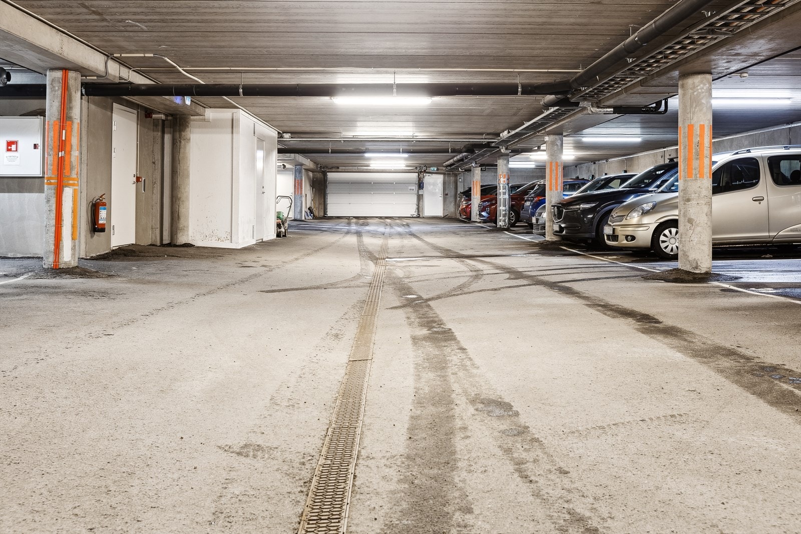 Romslig garasjeanlegg med god belysning og flere parkeringsplasser. Praktisk beliggenhet med enkel adkomst til boligen. Galleribilde