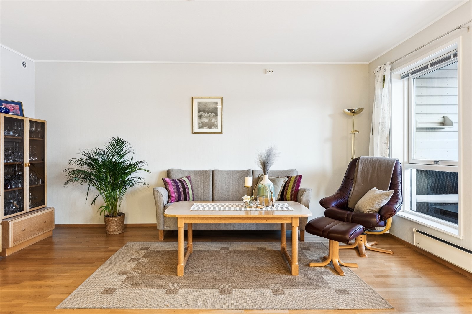 Lys og innbydende stue med store vindusflater som gir rikelig med naturlig lys. Perfekt for avslapning og sosiale sammenkomster. Galleribilde