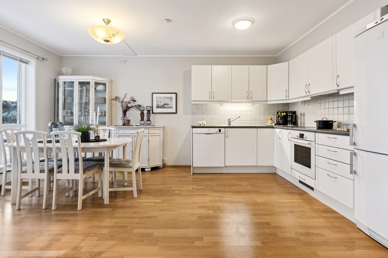 Lys og innbydende kjøkken- og spisestueløsning med moderne fasiliteter, perfekt for både hverdagsliv og selskapelige anledninger. Galleribilde