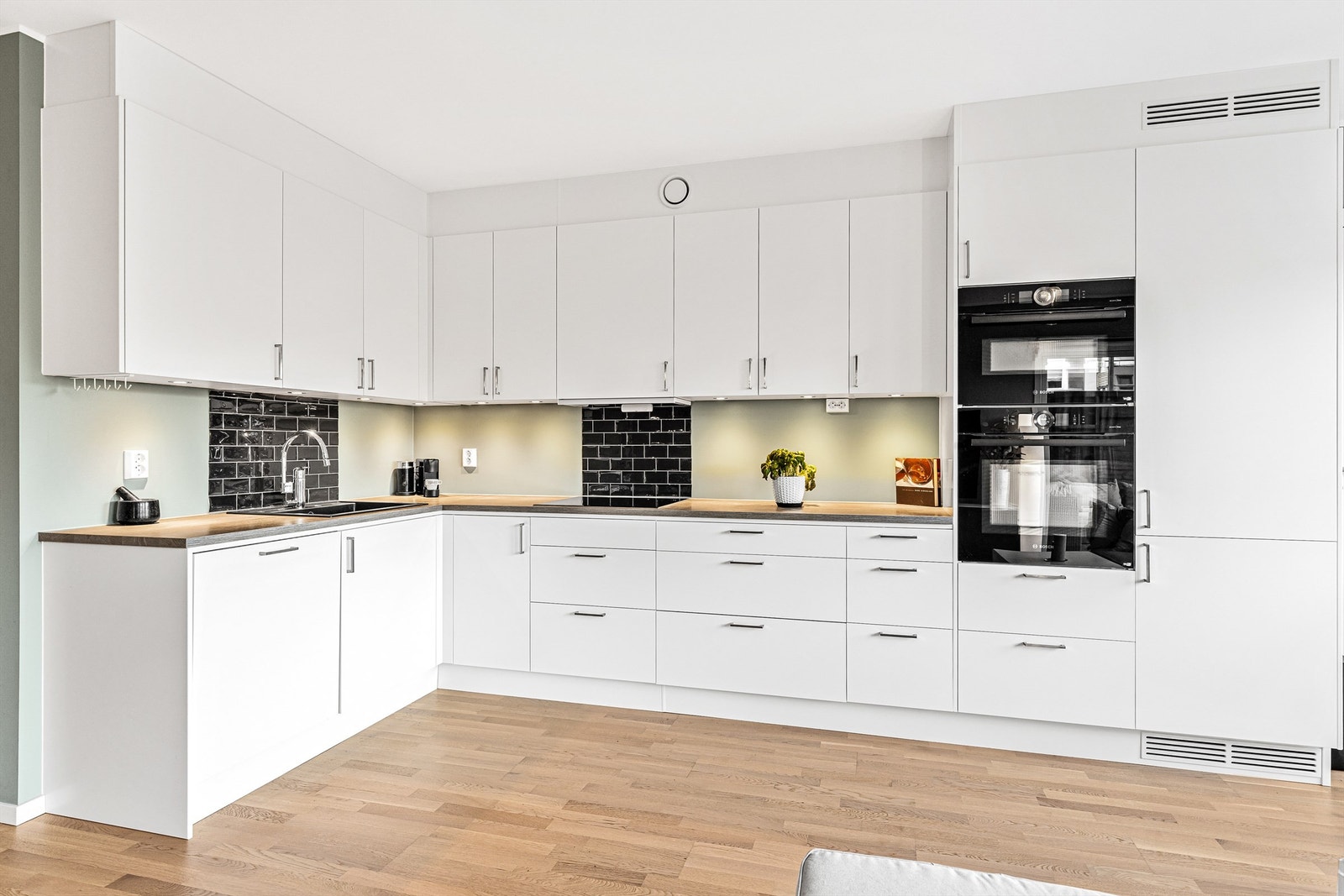 Her er det rikelig med oppbevaringsplass i både skuffer og skap, og den store benkeplaten gjør det enkelt og gøy å tilberede måltider. Galleribilde