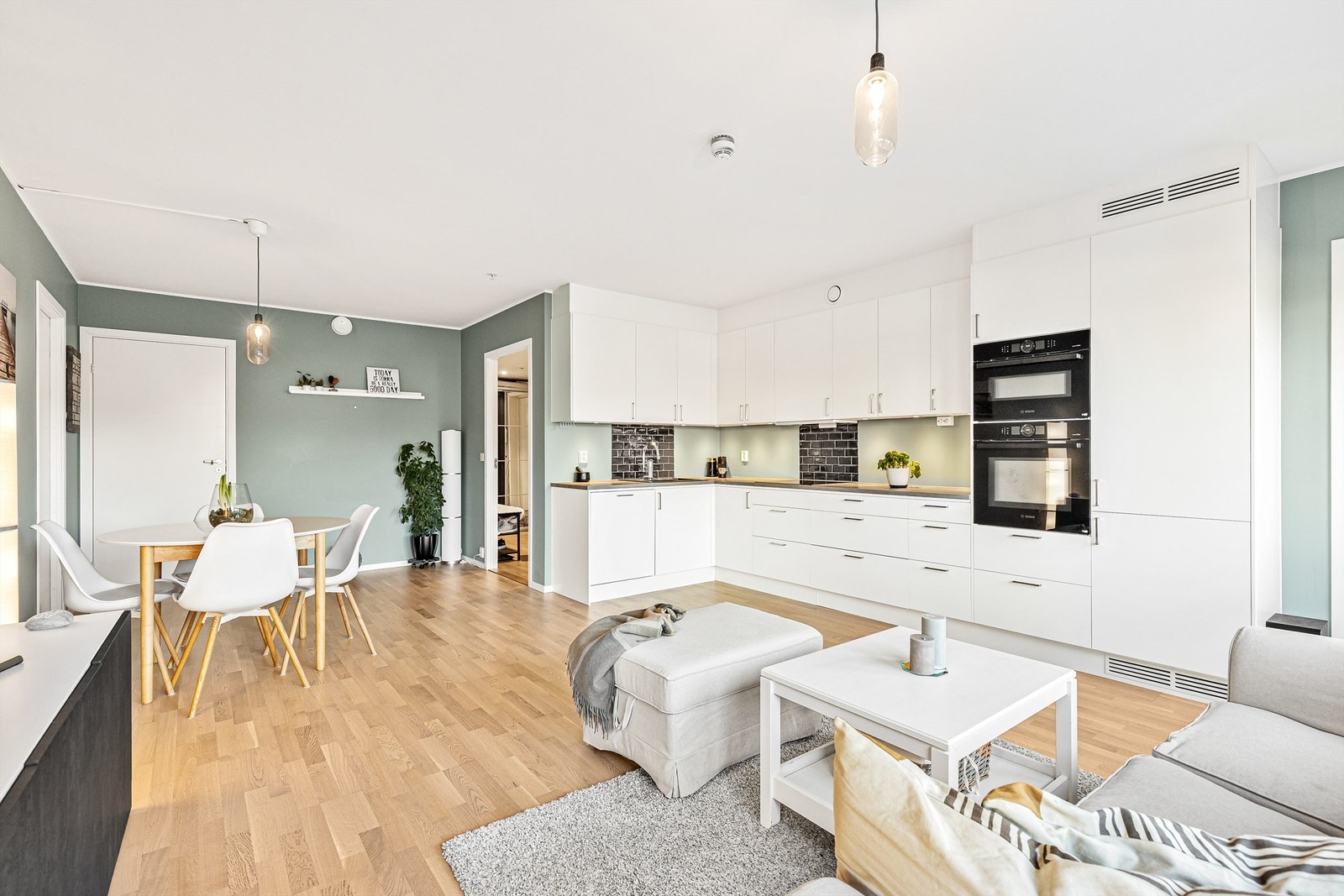 Kjøkkeninnredningen er av glatte fronter og laminat benkeplate med nedfelt vask, og har et tidløst og stilfullt uttrykk som passer godt med resten av rommet. Galleribilde