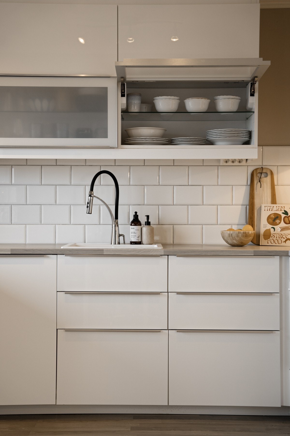 Det er fliser mellom overskap og underskap samt bak platetopp. Galleribilde