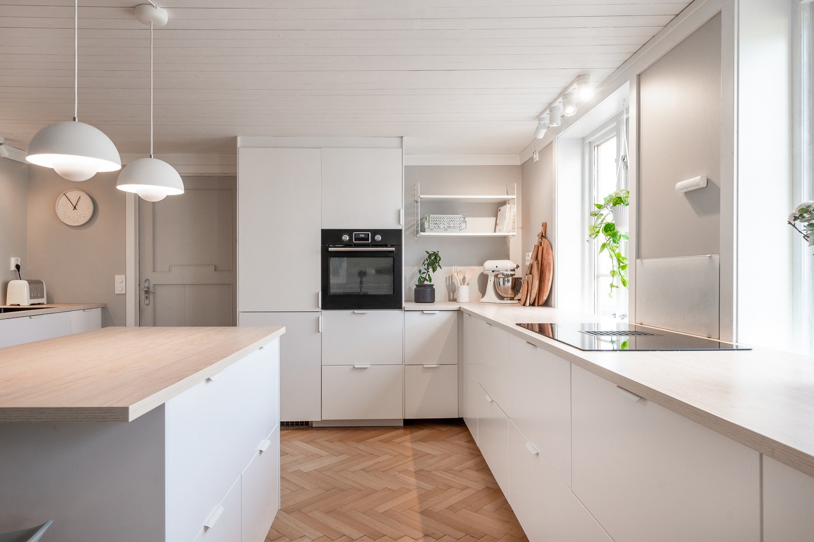 Kjøkkenet har slette hvite fronter og laminerte benkeplater. Galleribilde