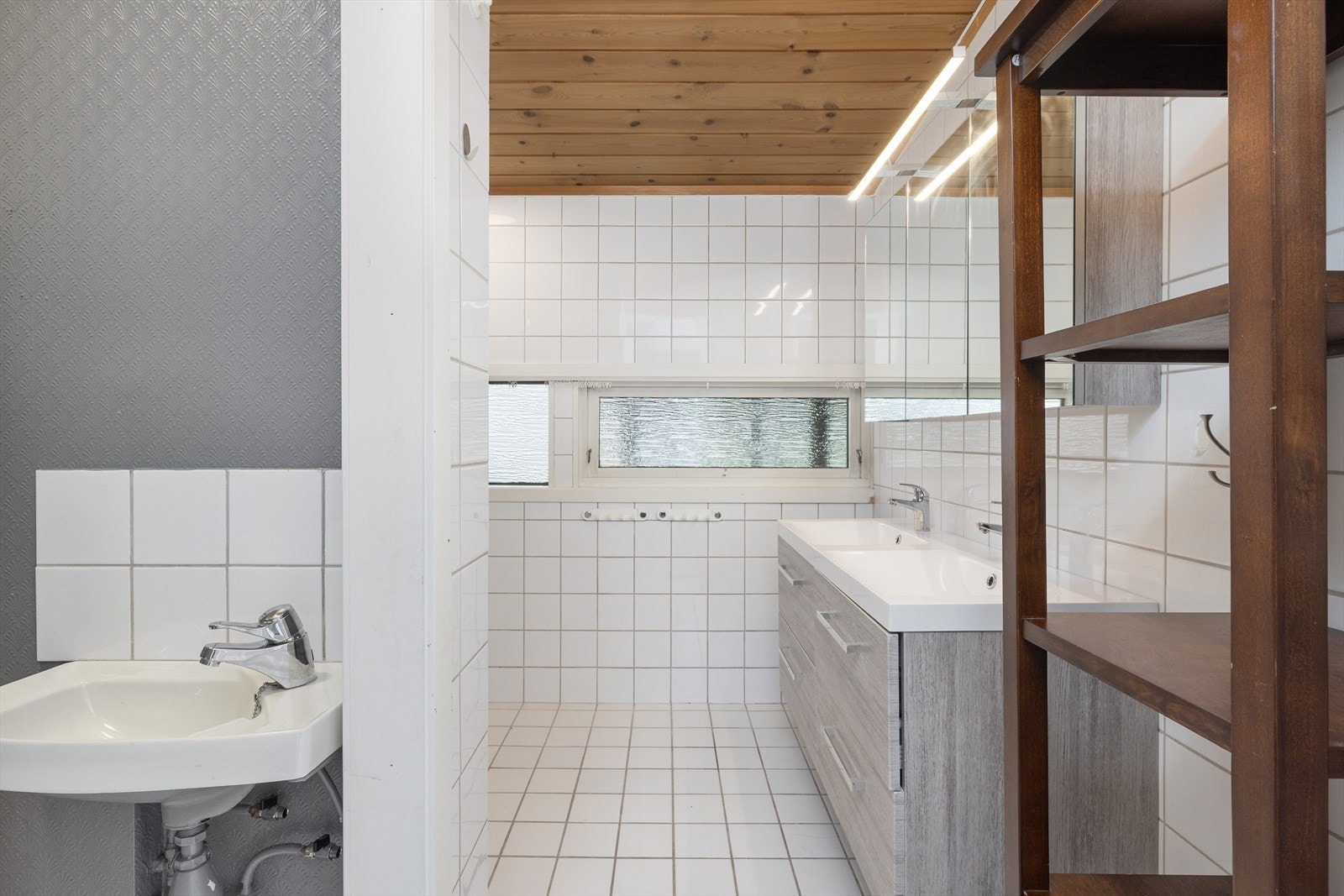 Badet i 1.etasje er innredet med dobbelservant på innredning, servant, toalett og dusjhjørne med glassvegger. Galleribilde