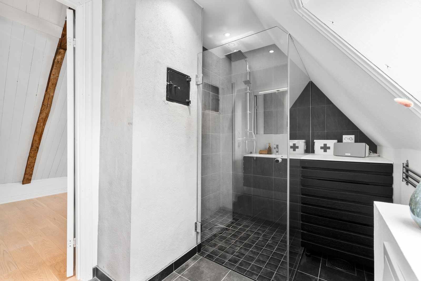 Badet i 2. etasje har sorte fliser på gulvet og malte hvite vegger. Galleribilde