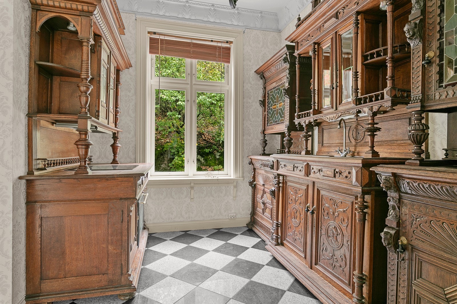 Kjøkkenet har flislagt gulv med varmekabler, historisk tapet på vegger og malte plater i himlingen. Galleribilde