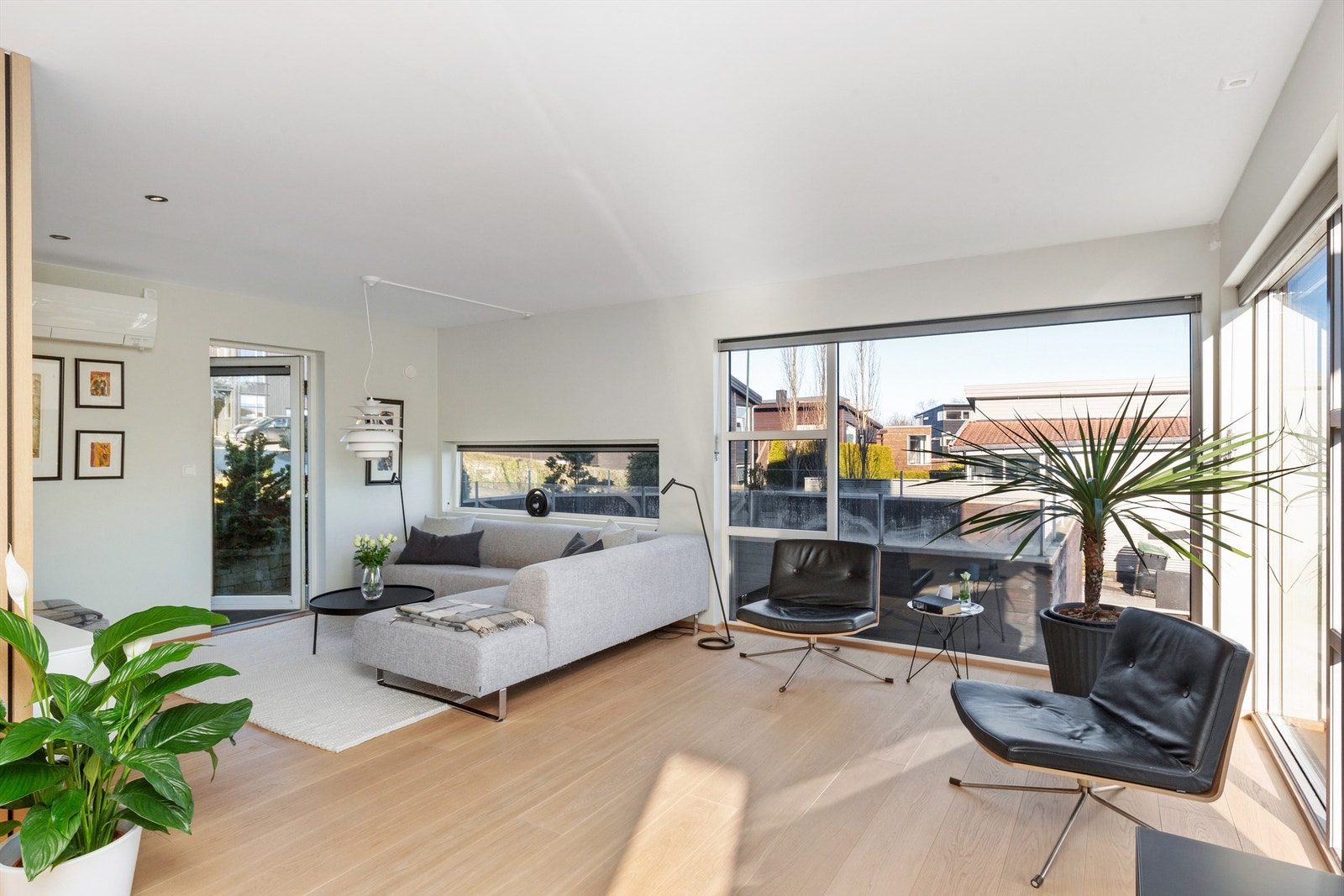 Romslig stue med plass til flere sitte grupper og utgang til terrasse Galleribilde