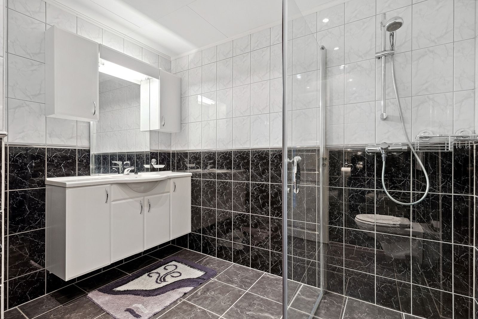 Moderne bad med stilige fliser - Leiligheten har eget vaskerom Galleribilde