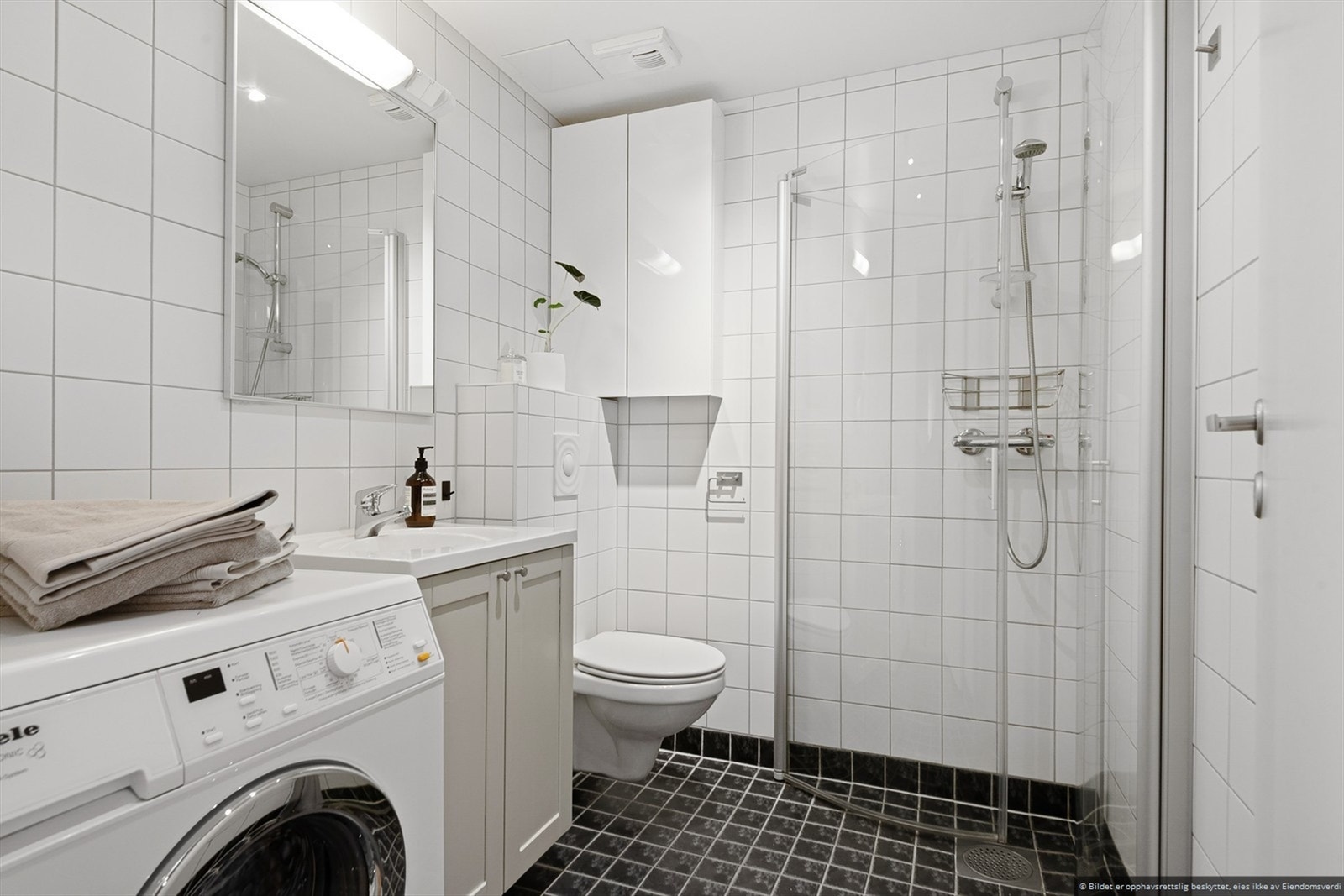 Pent flislagt bad med vaskemaskin. Galleribilde