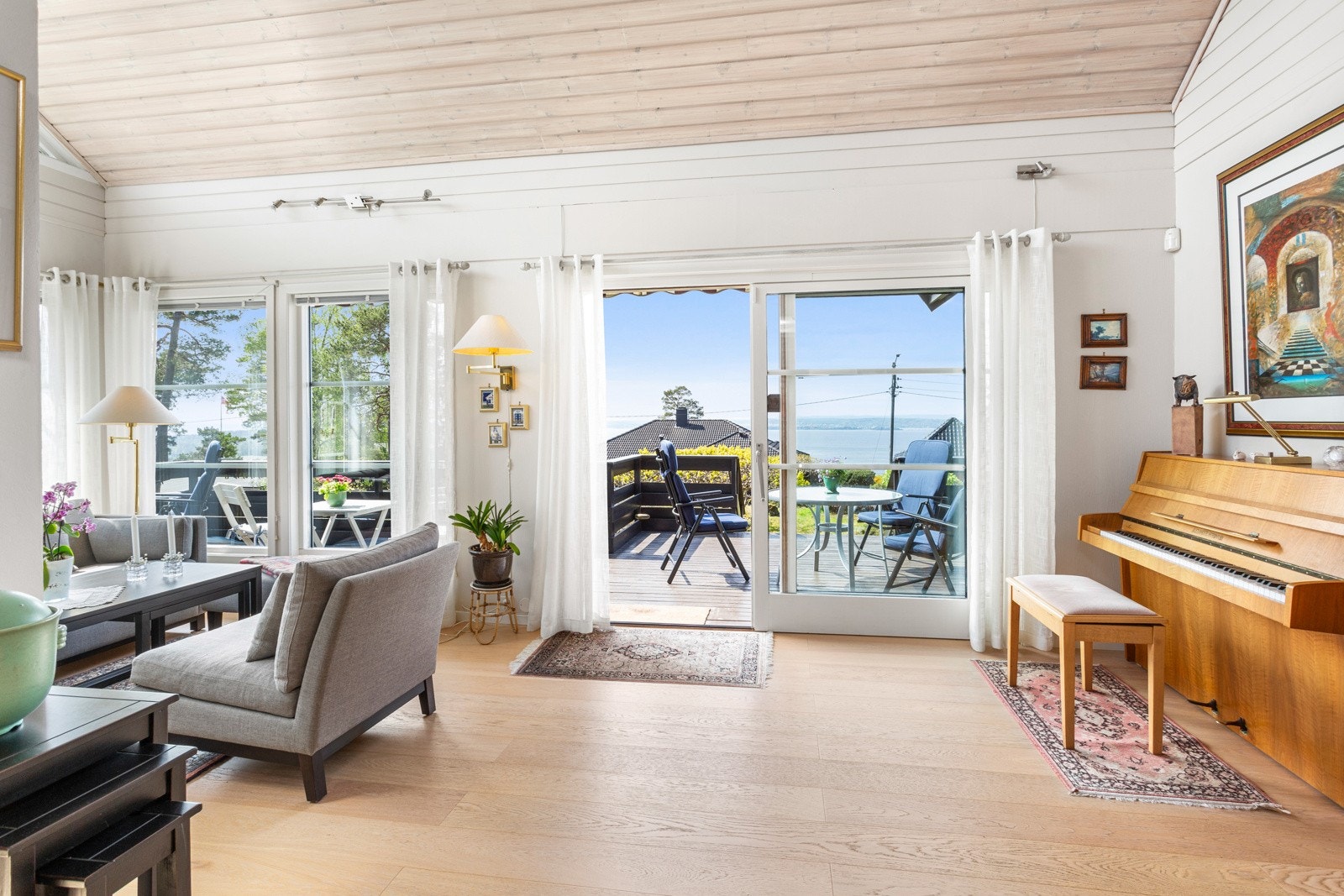 Den åpne stuen lar naturlig lys strømme inn i rommet via store vindusflater, og gir en følelse av luftighet og romslighet. Galleribilde