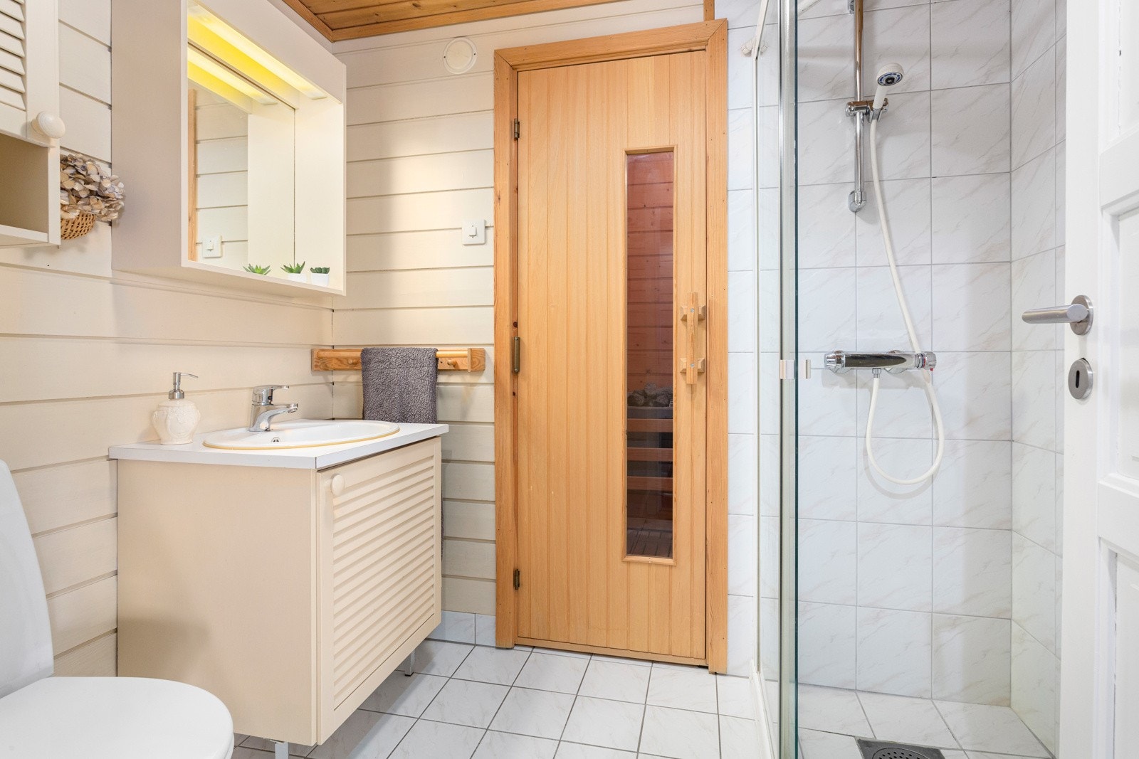 Badet er innredet med dusjhjørne, gulvstående wc og servantskap. Det er mekanisk avtrekk. Galleribilde