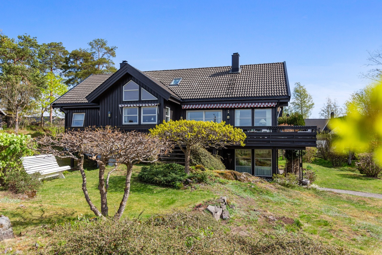 På denne store tomten, omgitt av naturlig voksende trær, finner du en stor enebolig med parkering i dobbel carport med bod i bakkant. Galleribilde