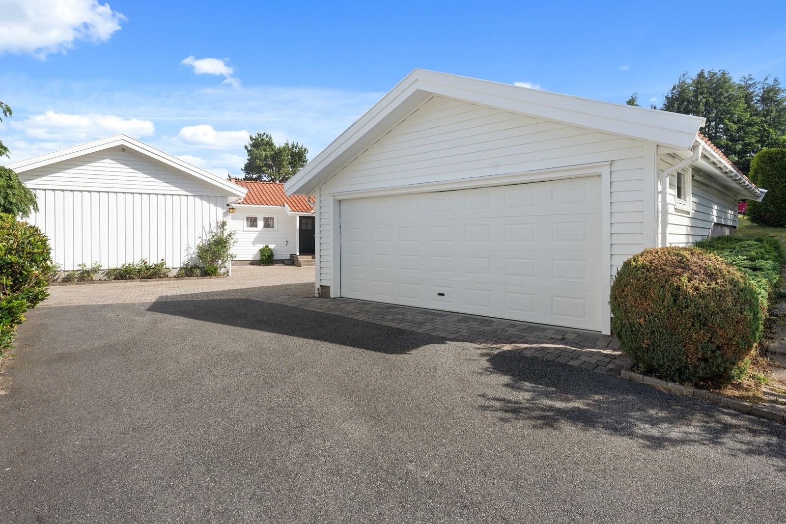 Innkjørselen er stor med dobbel garasje og asfaltert/steinlagt dekke. Galleribilde