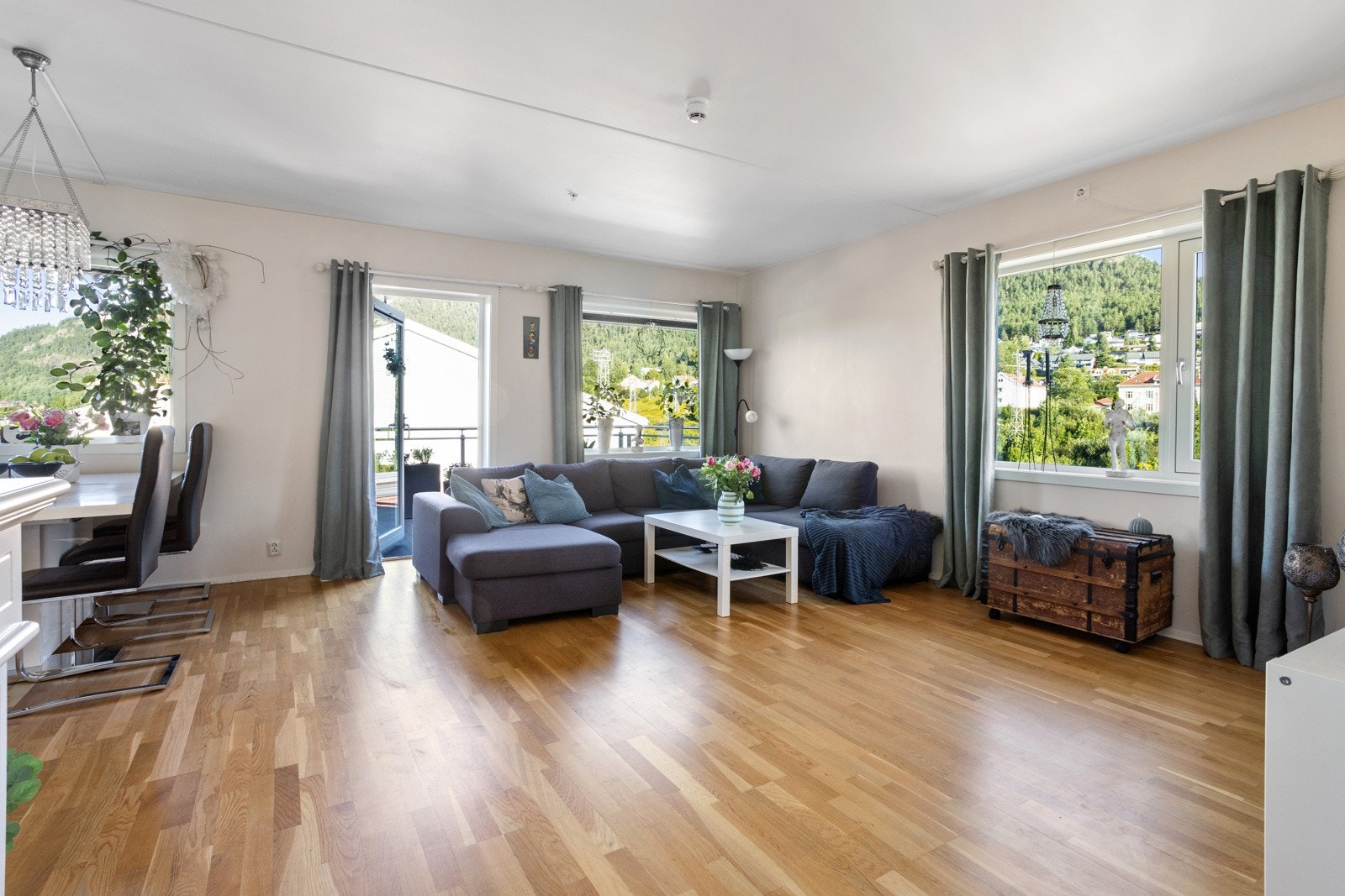 Store vinduer på to sider av stuen gjør at en kan nyte utsikten fra både salong og spisestuen Galleribilde