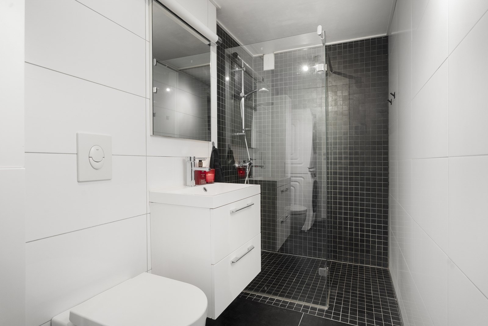 Pent bad/vaskerom av god størrelse. Badet er innredet med dusjnisje, vegghengt toalett, baderomsinnredning med heldekkende servant, speil med belysning, samt skap og opplegg/plass for vaskemaskin. Galleribilde