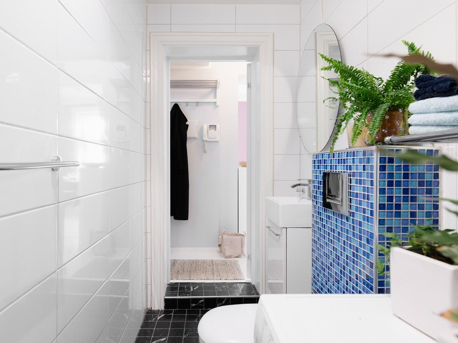 Badet er innredet med servant med servantskap, veggfestet toalett med skjult sisterne og dusjnisje med glassvegg/skyvedør. Galleribilde