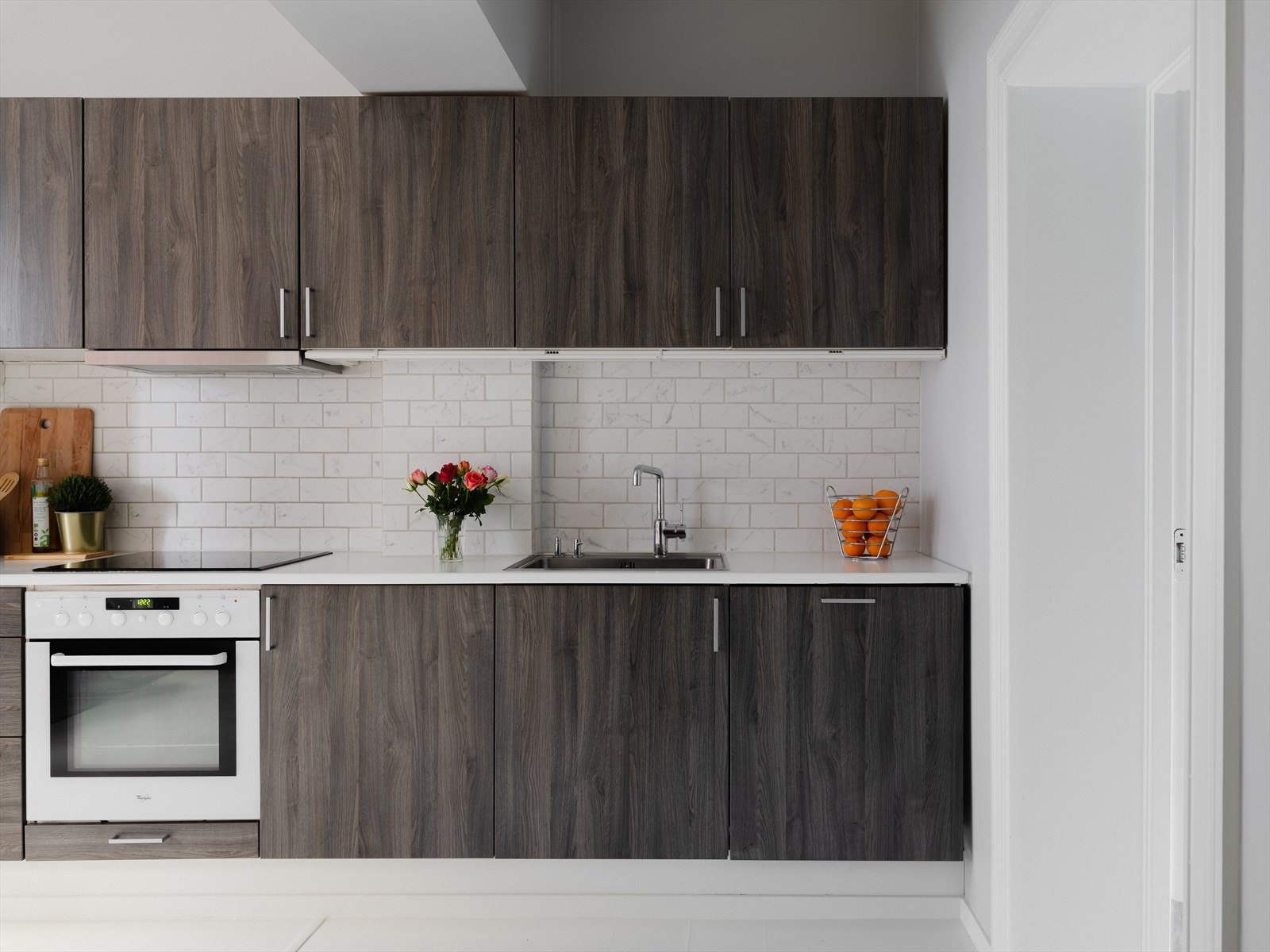 Innredning i mørk natur har en fin kontrast mot lyse fliser og benkeplate. Galleribilde