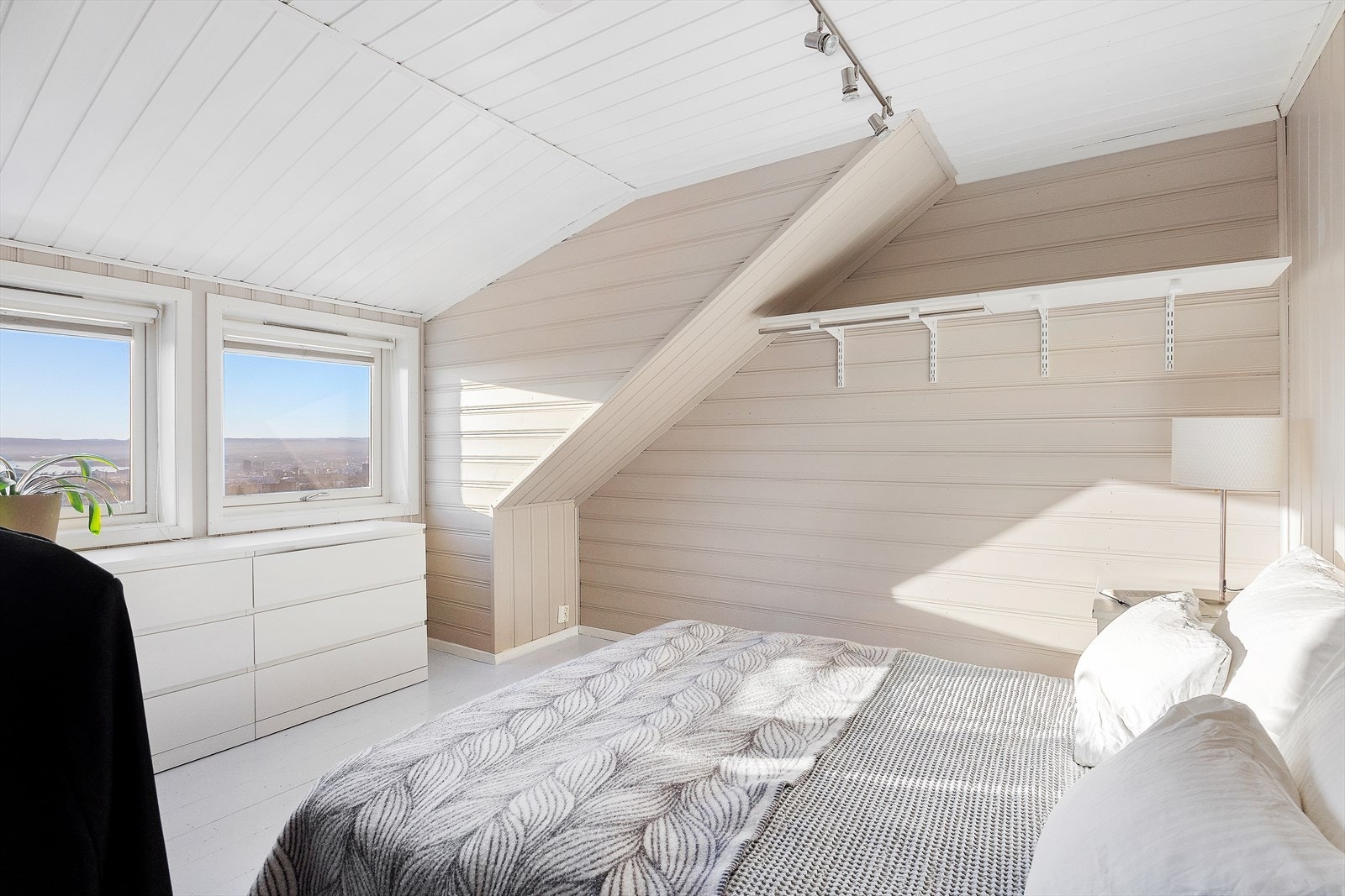 Soverom i loftsetasje med god plass til dobbeltseng og tilhørende nattbord Galleribilde