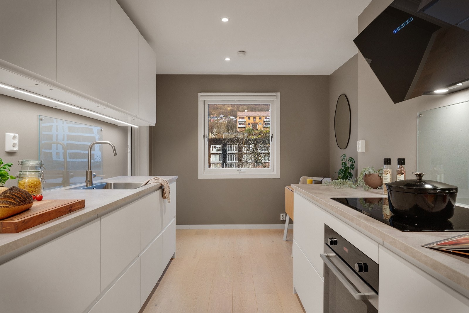 Et lekkert IKEA-kjøkken fra 2019 med hvite glatte fronter og laminert benkeplate med planlimt kjøkkenvask, Galleribilde