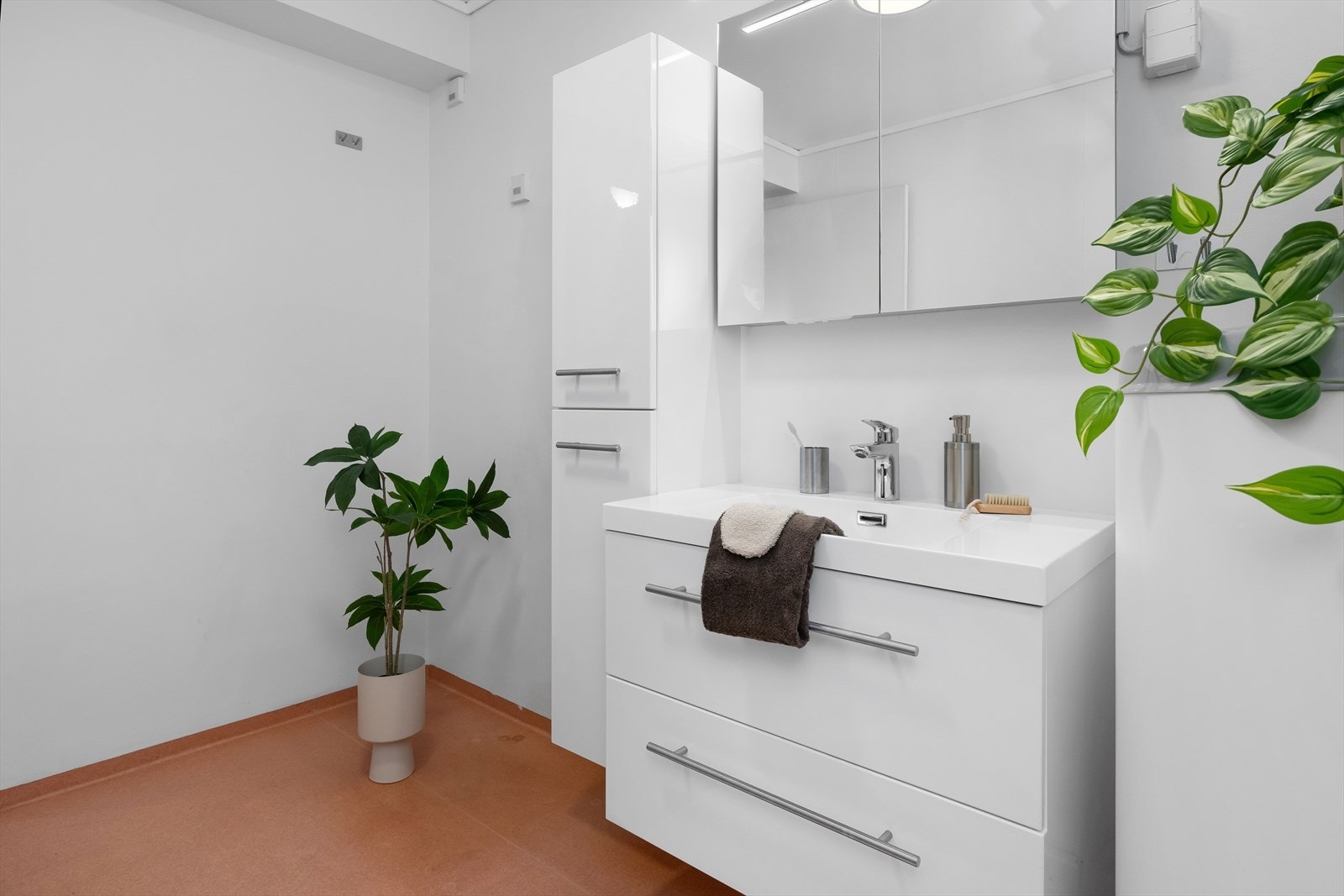 Baderomsinnredningen er i lys og slett utførelse med skuffer under den heldekkende servanten. Overskapene har speilfronter. Galleribilde