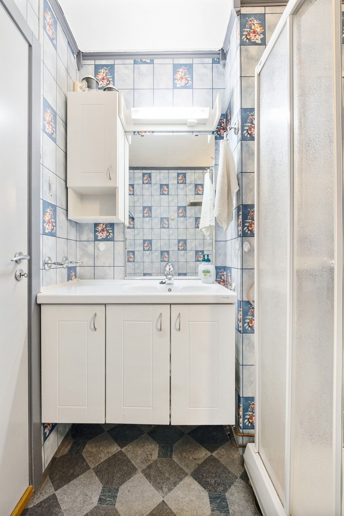 Rommet har hvit servantinnredning med lys over speil. Galleribilde