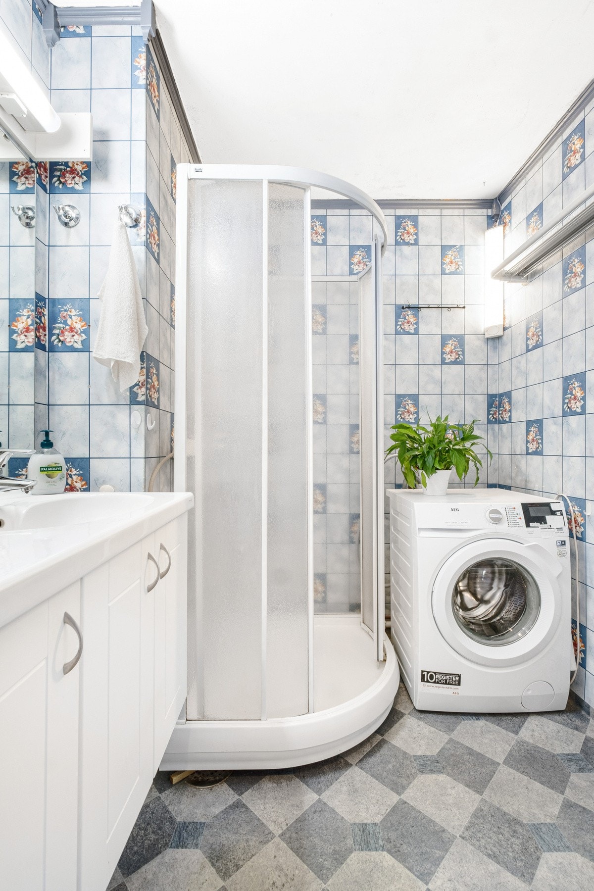 Bad med dusjkabinett, innredning og opplegg for vaskemaskin. Galleribilde