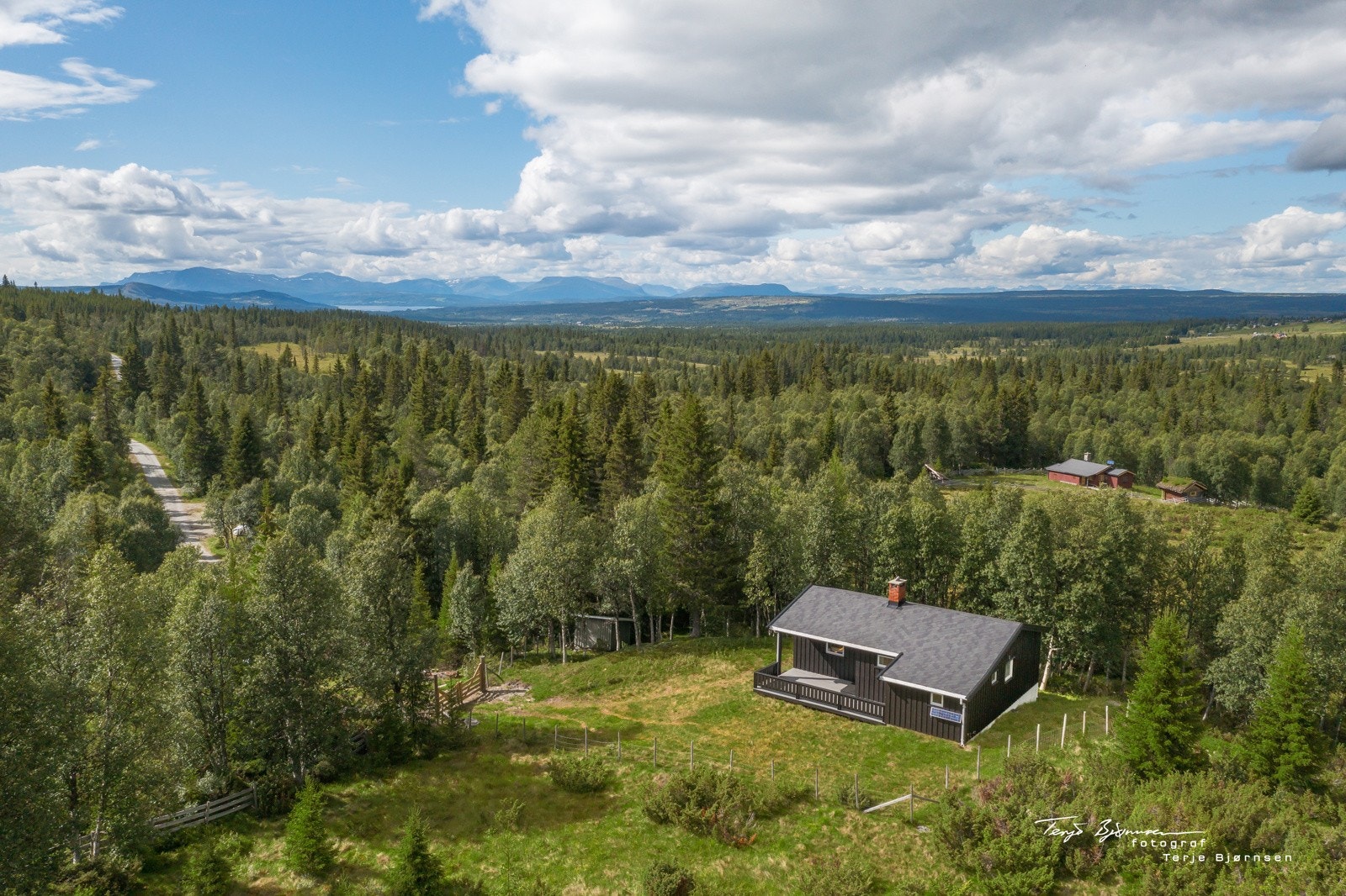 Oversiktsbilde av eiendommen med utsikt mot fjellene omkring Galleribilde