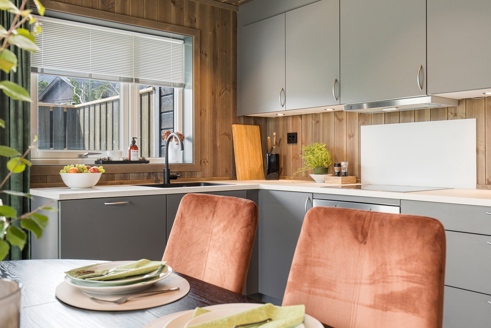 Kjøkkenventilator med avtrekk ut. Fuktbestandig plate på veggen over koketopp. Galleribilde