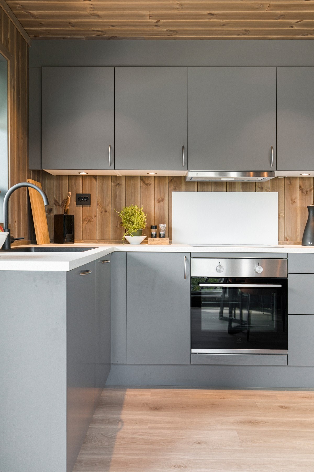 AUBO kjøkkeninnredning med glatte grålakkerte fronter og laminat benkeplate. Galleribilde