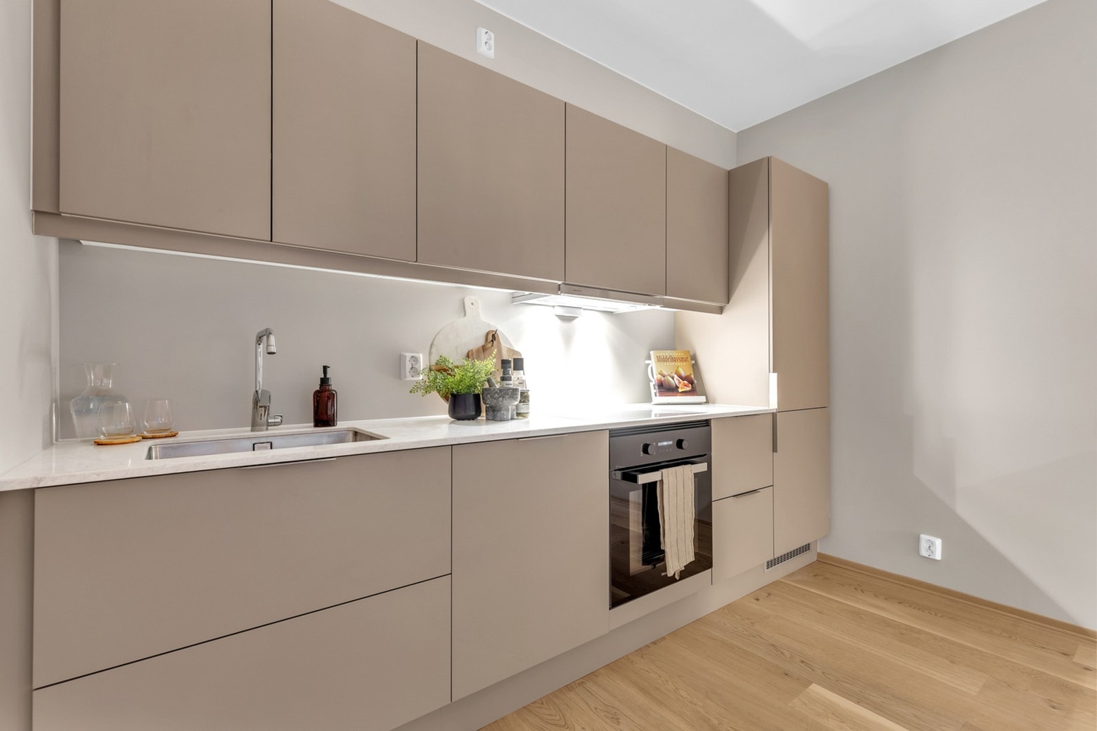 KJØKKEN| Benkeplate er oppgradert til den lekre typen Cæsarstone 6131 Bianco Drift med underlimt vask med stålkum og planlimt platetopp. Galleribilde