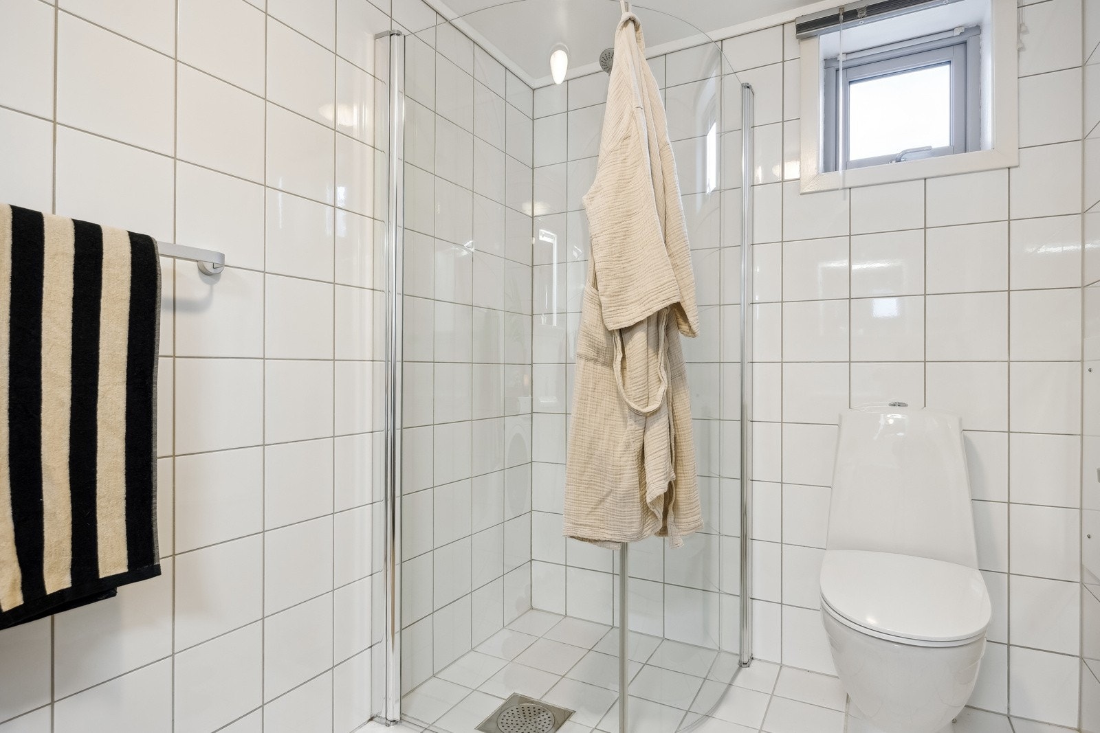 Rommet er utstyrt med wc, dusj m/innfellbare dusjvegger og baderomsinnredning med skap for oppbevaring av håndklær og toalettartikler. Galleribilde